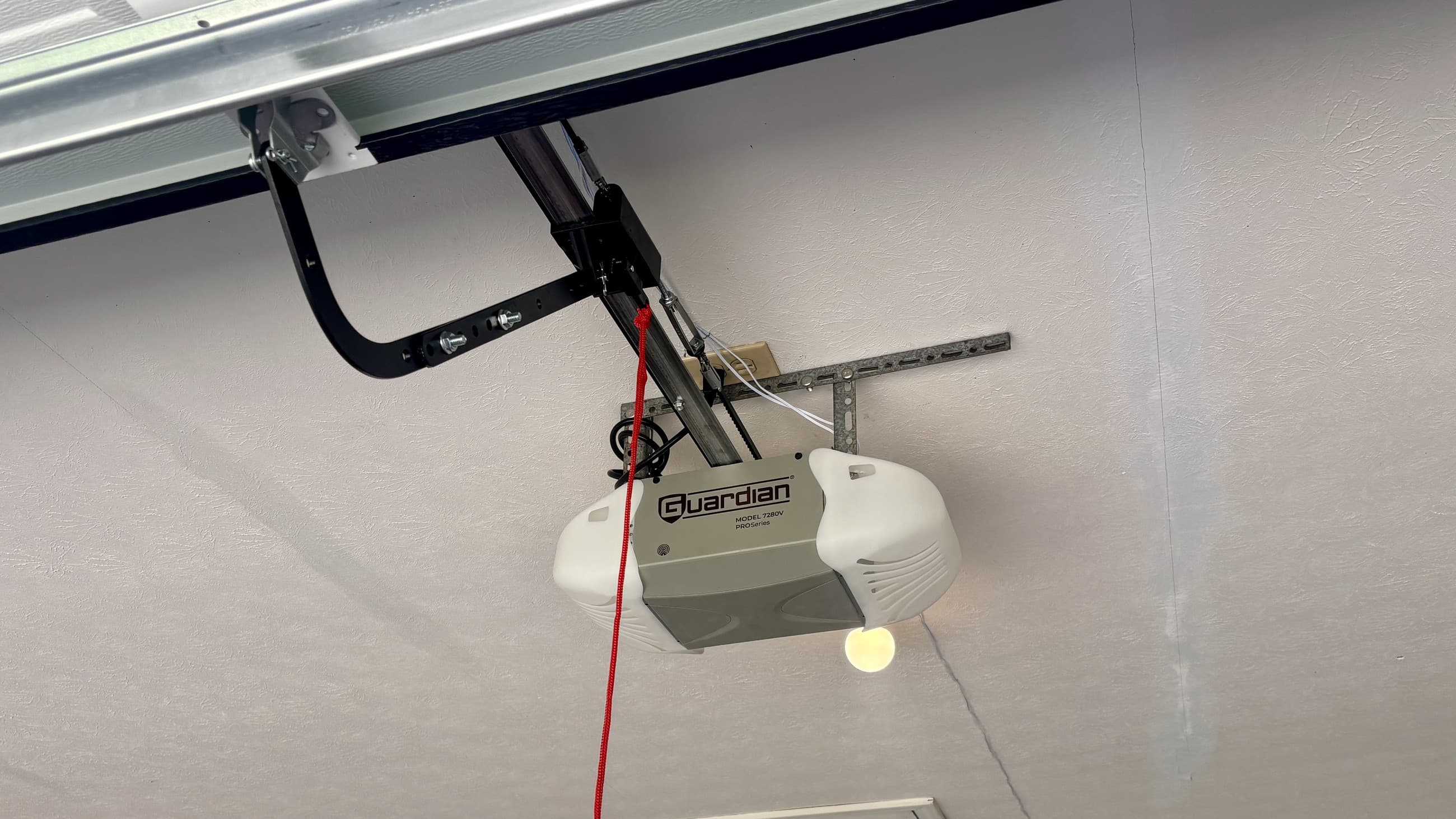 A Guardian 7280V PROSeries belt-drive opener mounted above a garage door