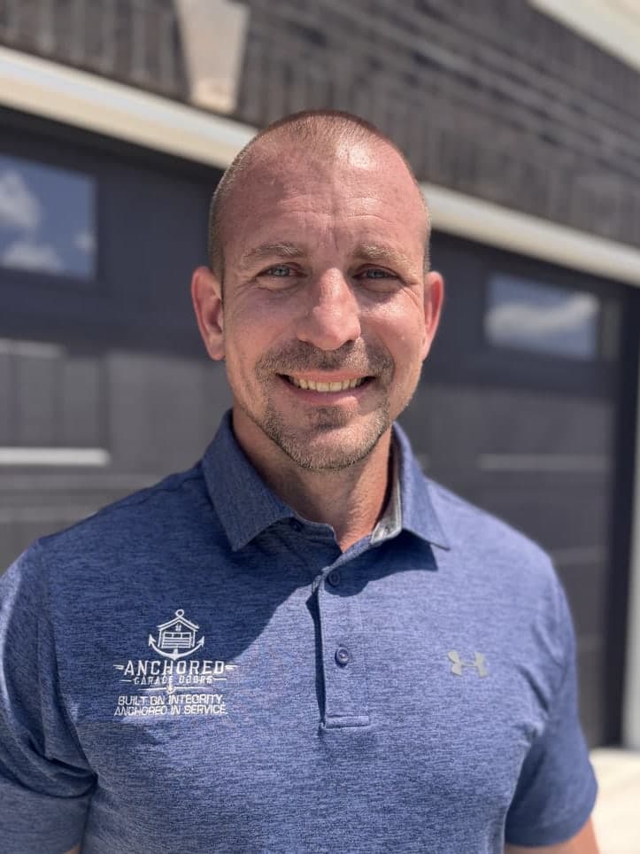 Jacob Schneider in an Anchored polo shirt, outside a finished garage door