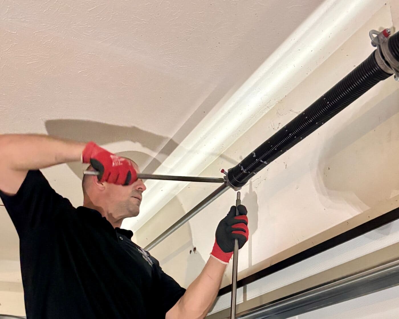 A torsion spring being replaced above a customer’s door.