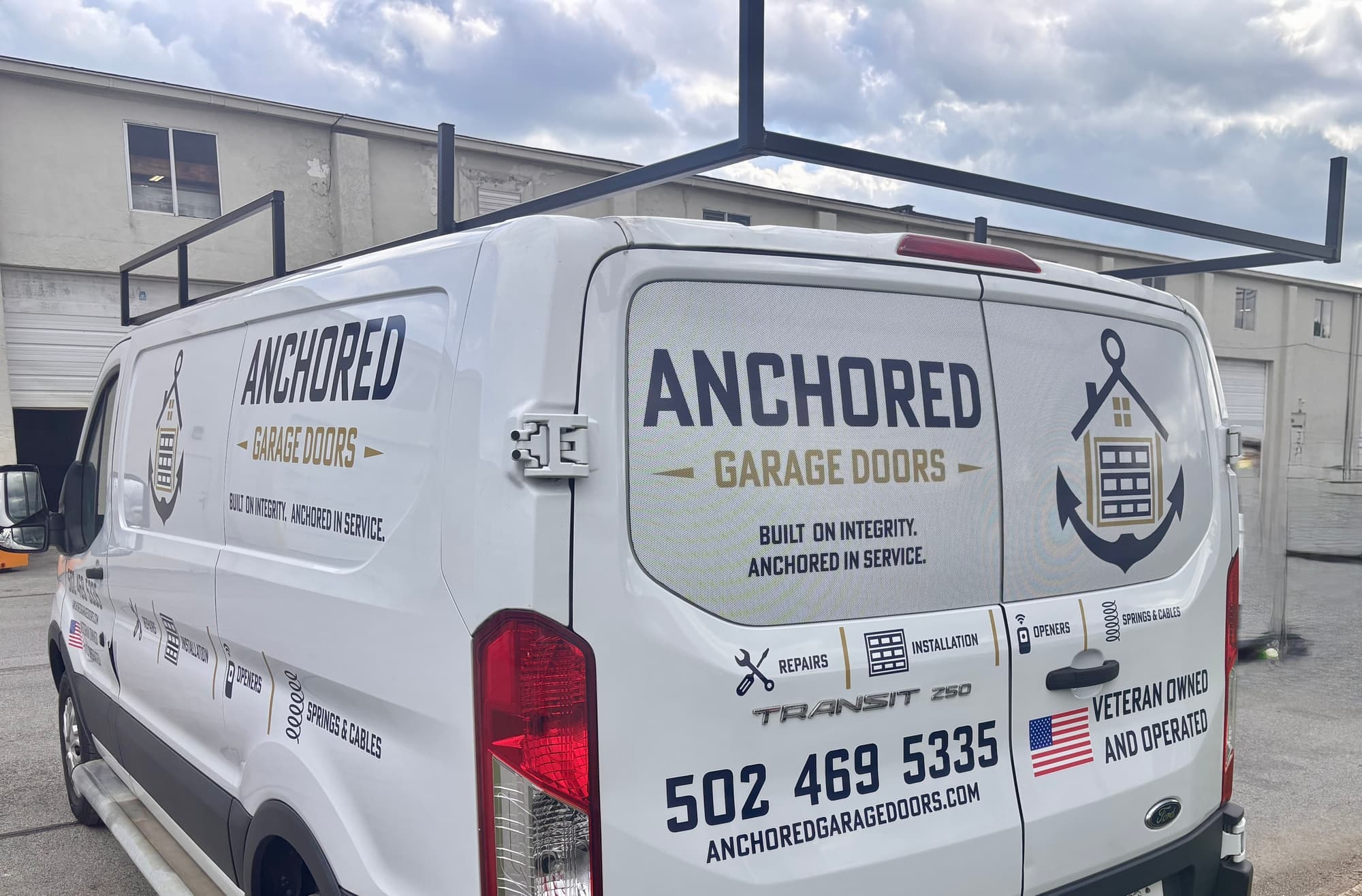 The back of the wrapped Anchored Garage Doors van, with the phone number and website on the doors