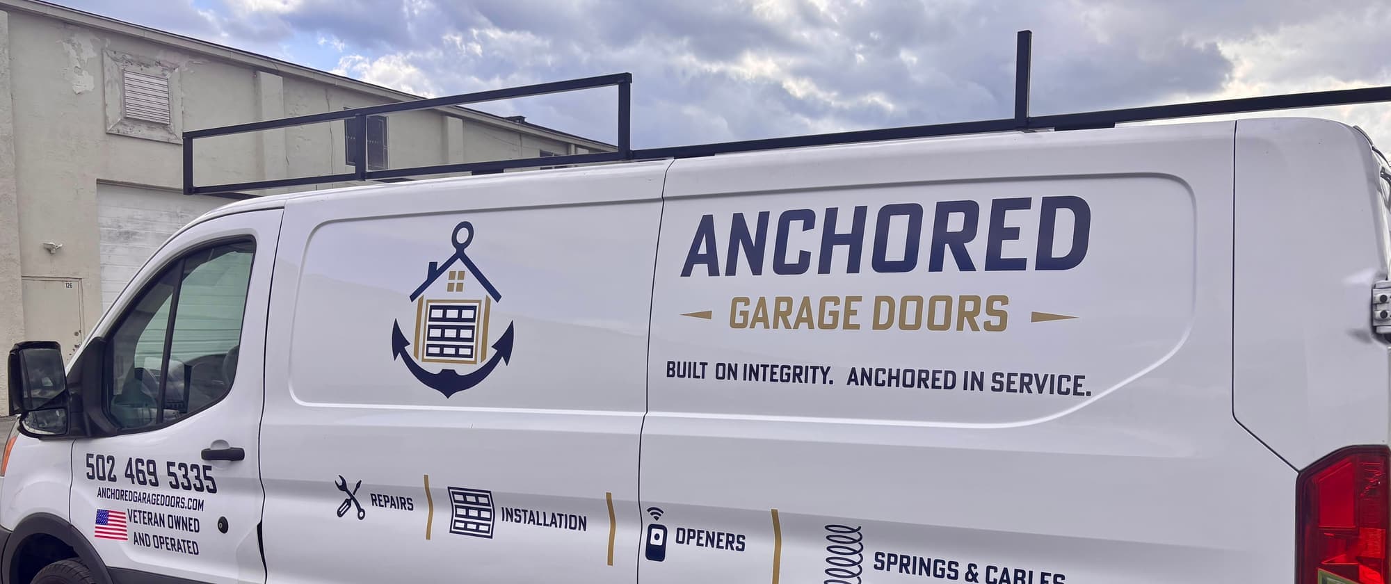 The wrapped Anchored Garage Doors van, side on, with the phone number and the services it carries